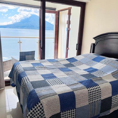 a bedroom with a bed with a view of the ocean at Penthouse con vistas espectaculares del Lago de Atitlán in Panajachel