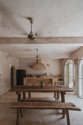 a large wooden table in a room with a kitchen at Villa Petit Comité in Mérida