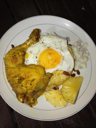 een bord met een ei en aardappelen bij Surf Kin Garden Inn in Weligama