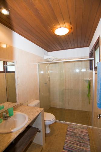 a bathroom with a toilet and a sink and a shower at Casa Giada Eleganza tropicale nel cuore di Praia do Forte in Praia do Forte