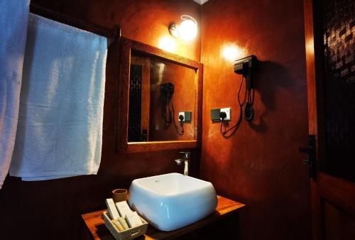 un bagno con un lavandino bianco e uno specchio di Villa Flower Zanzibar a Kiwengwa