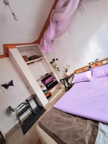 a bedroom with a bed with purple sheets at Homey Stay in Kampala