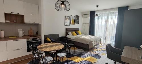 a bedroom with a bed and a table and chairs at Planet-A1012 in Niš