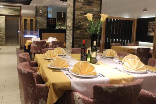 a dining room with tables and chairs with wine bottles at Hotel Blagaj Mostar in Blagaj