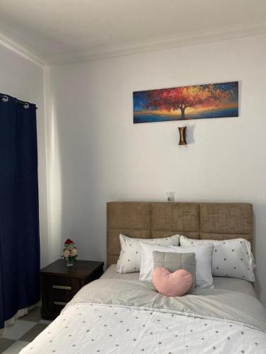 a bedroom with a bed with a pink pillow on it at EdenRose Guest House in Kwabenya