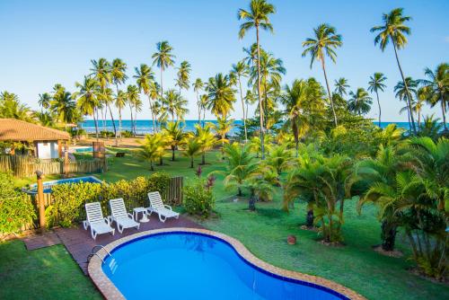 an aerial view of a resort with a pool and palm trees at Casa Giada Eleganza tropicale nel cuore di Praia do Forte in Praia do Forte