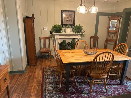 een eetkamer met een houten tafel en stoelen bij The Allen House in North Adams