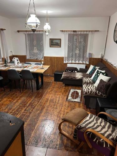 a living room with a table and a dining room at Chata Jizerky in Polubný