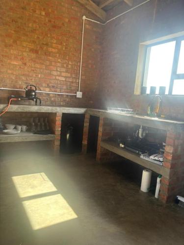 a room with a brick wall and a counter and a window at Askop Tented Escape & Adventure in The Crags