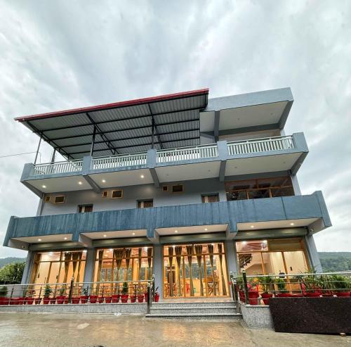 un grand bâtiment avec beaucoup de fenêtres dans l'établissement Rivana Retreat, à Dehradun