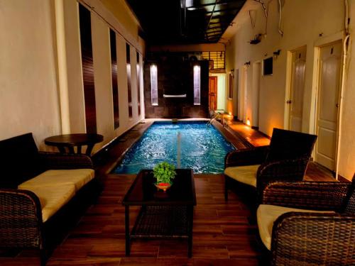 a swimming pool with couches and a table in a room at Hotel Begrand in Tapachula