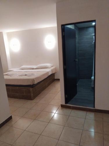 a bedroom with a bed and a glass shower at Hotel Begrand in Tapachula