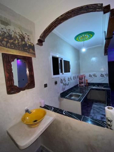 een badkamer met een gele wastafel en een spiegel bij Adrar N Darn Guesthouse in Taroudant