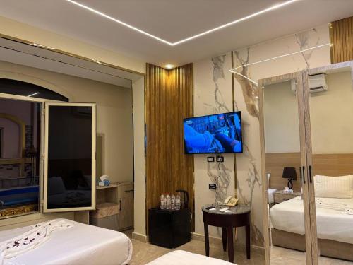 Un dormitorio con dos camas y un televisor de pantalla plana. en Nisut Pyramids Hotel, en El Cairo