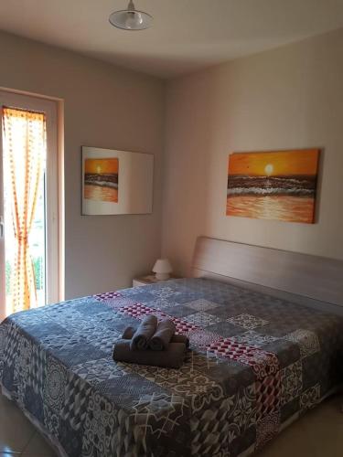 a bedroom with a large bed with a blue blanket at Complesso "I Giardini Elisei" in Policoro