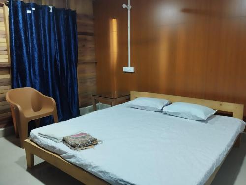 尼尔岛Sea Sand Resort的卧室里有一张带蓝色窗帘的床