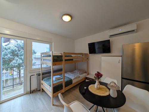 a small room with a bunk bed and a table at Sesvete Studio 4 Four in Sesvete