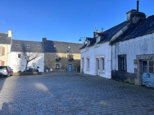 una strada di ciottoli in un centro storico con edifici di Le Petit Cocon de Pleyben a Pleyben