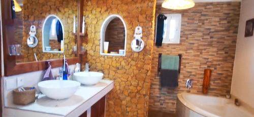 ein Badezimmer mit zwei Waschbecken und zwei Spiegeln in der Unterkunft OROKA EDEN in Ambondrona