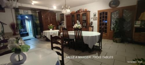 een eetkamer met een witte tafel en stoelen bij Chambres D'hôtes Mongarny Cancale in Cancale