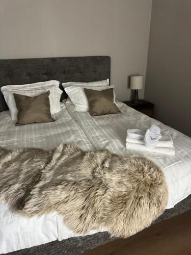 a white bed with a fur blanket on it at LyNora Lodge 