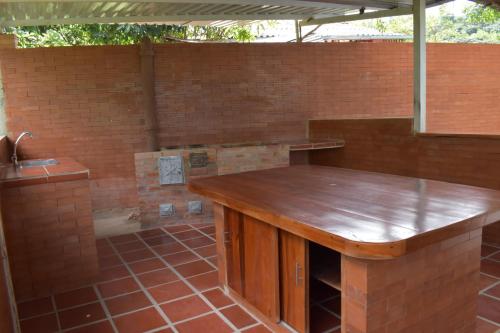 eine Küche mit einer Holztheke in einer Ziegelwand in der Unterkunft Finca el Paraiso Casa Loma, Tena in Tena