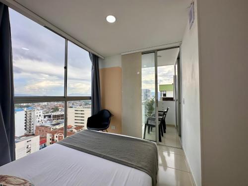 Un dormitorio con una cama y vistas a una ciudad. en Amoblados Casa de Pinos Bucaramanga, en Bucaramanga
