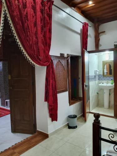 a room with a bathroom with a sink and a door at Riad el wazania in Rabat