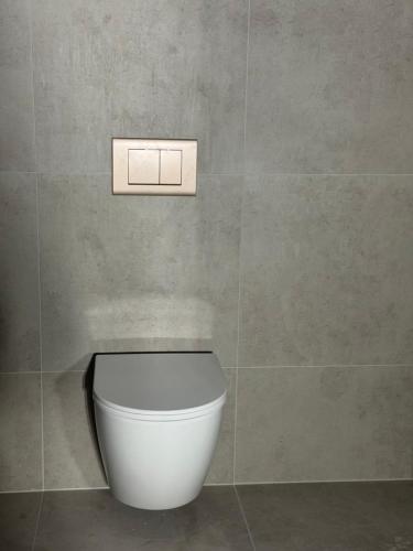 a bathroom with a white toilet in a wall at LyNora Lodge 