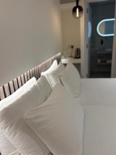 a white bed with white sheets and pillows at RIOSHOUSE Henley in Henley on Thames