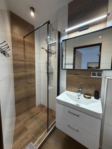 a bathroom with a sink and a shower at Dom Wczasowy Barbara in Karwia