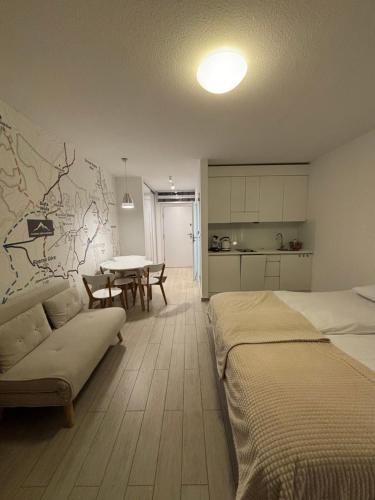 a bedroom with a bed and a table and a kitchen at Najładniejszy Apartament w Czarna Góra Resort - Livigno - Sienna in Sienna