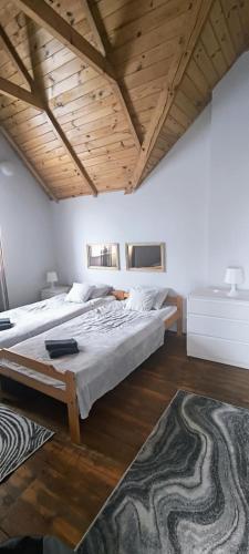 a bedroom with a large bed and wooden ceilings at Willa Baśka in Chańcza