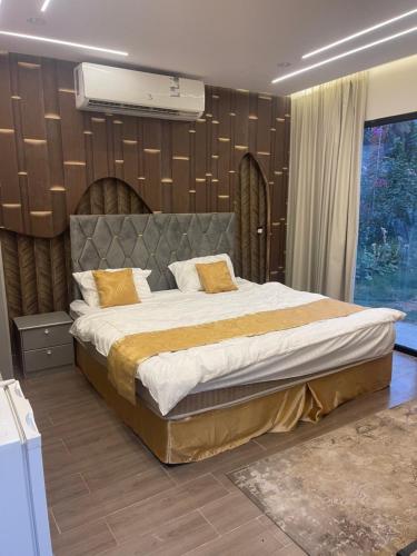 Un dormitorio con una cama grande en una habitación. en شاليه نخله, en Al Ula