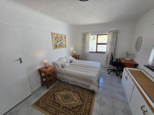 a bedroom with a bed and a desk and a window at Alvera in Strand