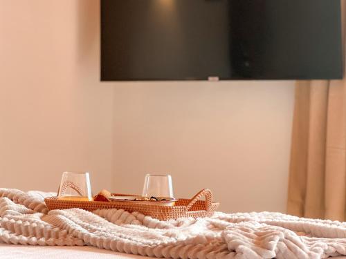 Una mesa con dos copas de vino y una manta. en Canaryislandshost l The Sky Suites, en Tinajo