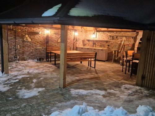 a wooden table in a room with snow on the floor at Luxusny apartman z tarasmi - Vera in Telgárt