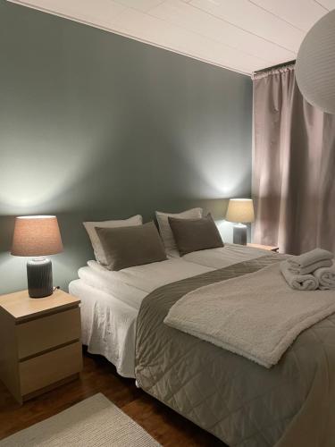 a bedroom with a large bed and two lamps at Lovely two room unit with free parking in Kuopio