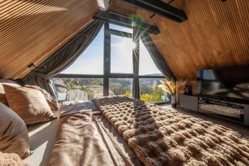 a large bed in a room with a large window at LoveNest Hungary in Győrújbarát