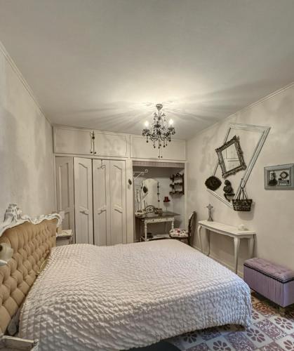a bedroom with a bed and a chandelier at Le Domaine de Cécile by Alto Service in Perpignan