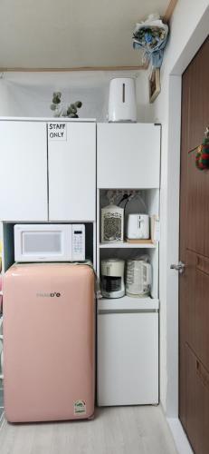 a pink refrigerator with a microwave on top of it at 베델하우스 Bethel House in Seoul