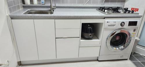 a kitchen with a sink and a washing machine at 베델하우스 Bethel House in Seoul