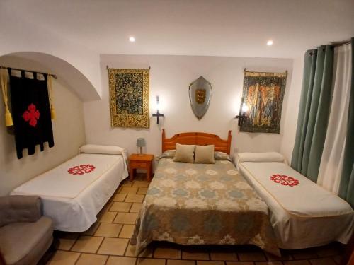 a hotel room with two beds and a couch at Hotel Rural Hospedería de los Calatravos in La Calzada de Calatrava