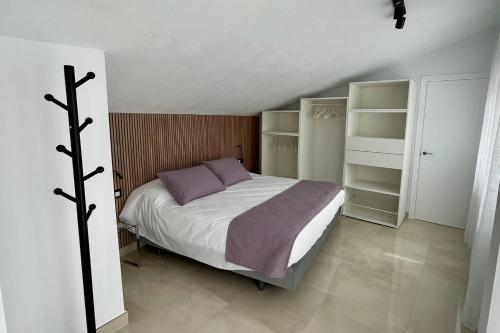 Un dormitorio con una cama y estantes. en Principado de Aracena I, en Aracena