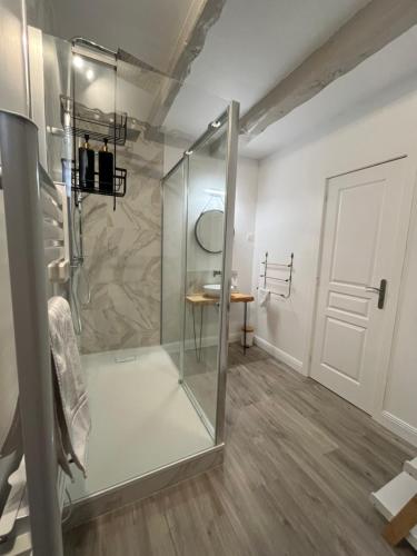 a bathroom with a shower with a glass door at Le Domaine des Songes in Saint-Maden