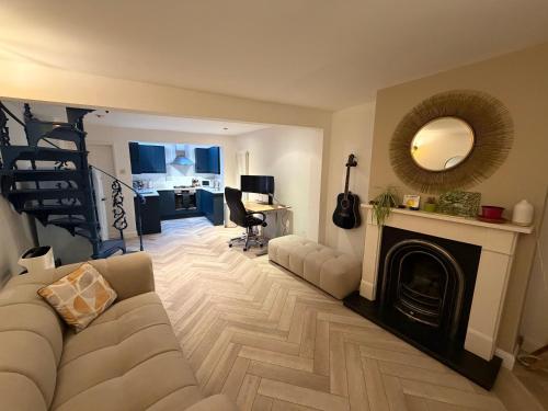 a living room with a couch and a fireplace at Victorian Cottage in Central Richmond in Richmond upon Thames