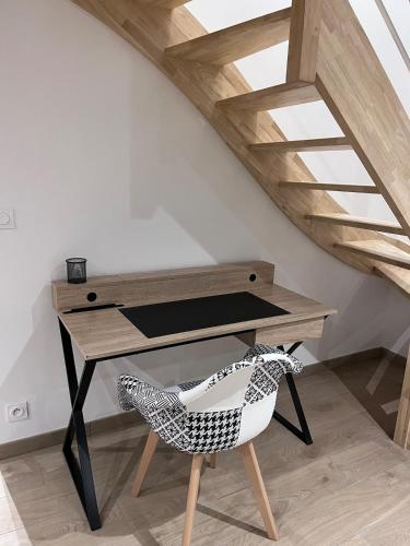 escritorio y silla en una habitación en La p'tite maison, en Courgains