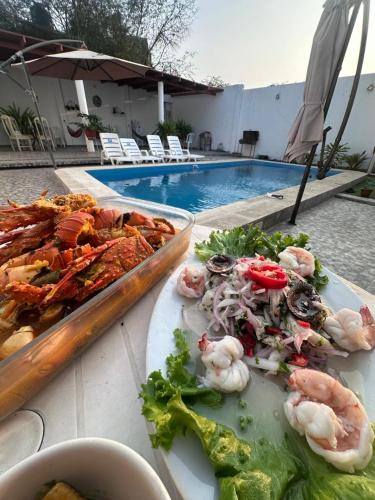 a buffet of food on a table next to a pool at Casa de playa Iberico in Caleta Grau
