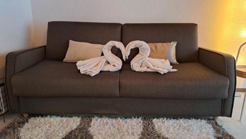 a brown couch with two pink pillows on it at Très joli studio au centre de la station in Anzère