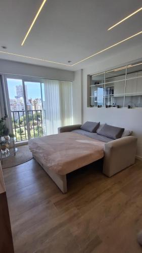 a bedroom with a large bed in a room with large windows at Vista y confort - Cerca de todo in Mar del Plata